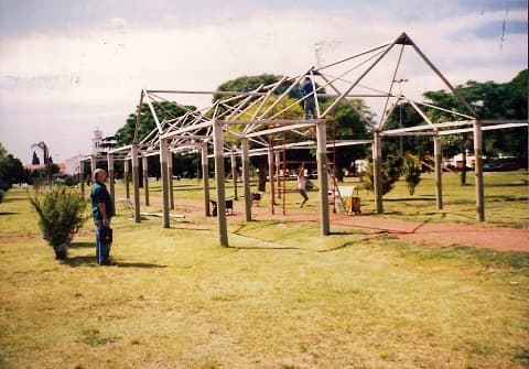 Parque con palmeras, banco azul y césped del barrio Cornelio Saavedra